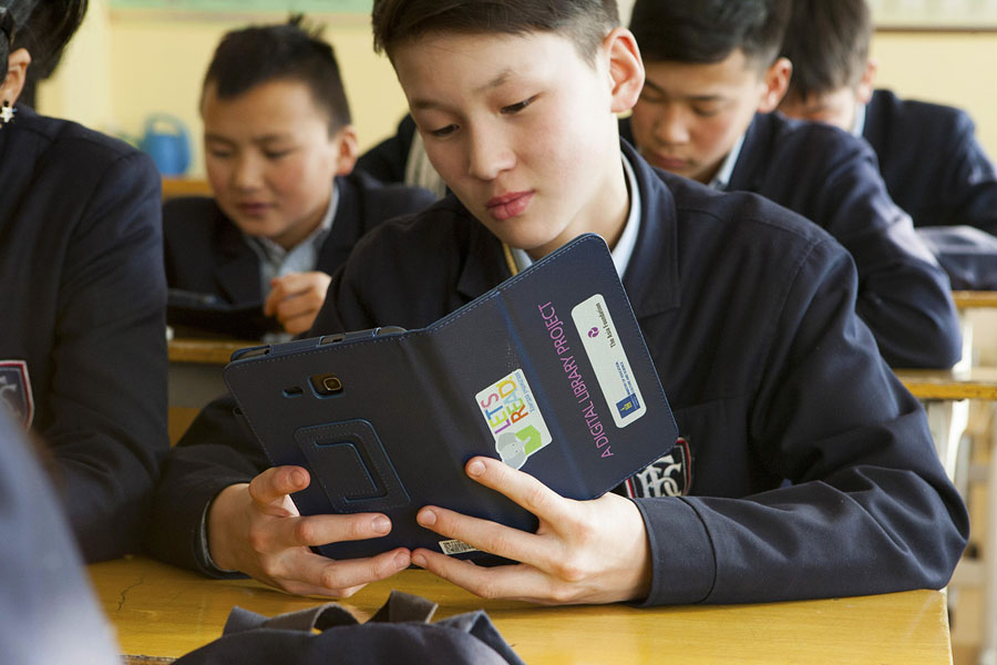 Child reads an e-book using a tablet donated by The Asia Foundation